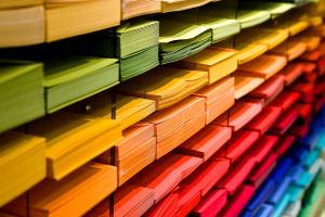 Regal mit farbig sortierten Papierstapeln