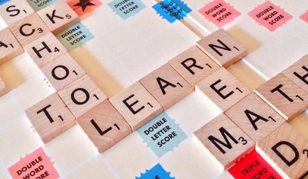 Ausschnitt eines Scrabblespielbretts, auf dem die Wörter Learn, School, Math und Read gelegt sind