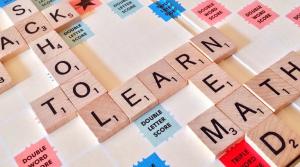 Ausschnitt eines Scrabbelspiels mit Spielsteinen, die die Wörter Learn, School, Math und Read bilden