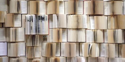 Eine Wand, die aus aufgeschlagenen Büchern besteht