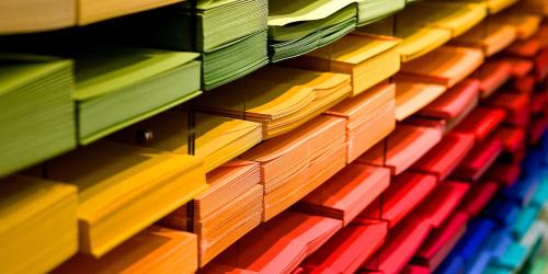 Regal mit farbig sortierten Papierstapeln