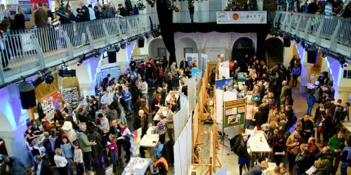Messestände mit Menschen in einer großen Halle