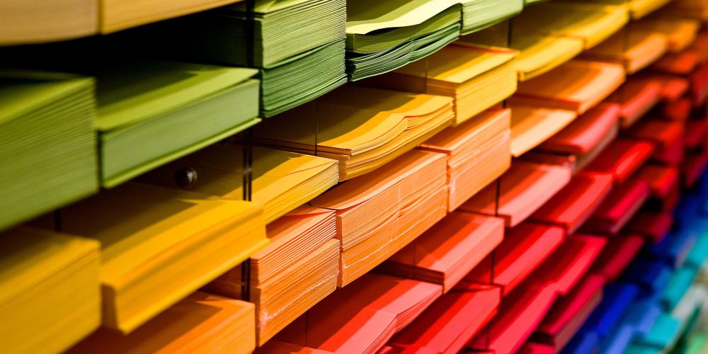Regal mit farbig sortierten Papierstapeln