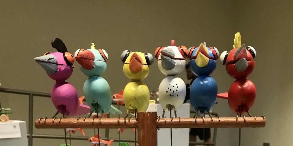 Ein Automat mit holzgeschnitzen bunten Vögeln